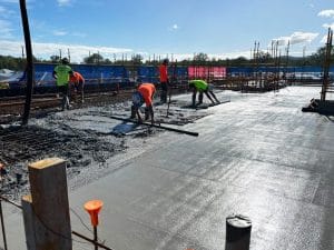 Laborers laying concrete slab for retirement community