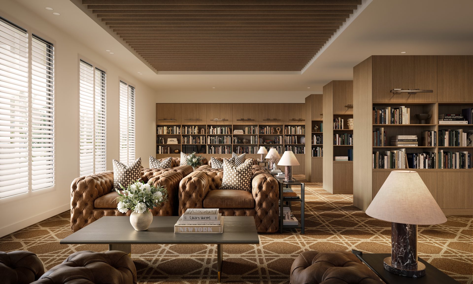 Elegant resort-style library and lounge featuring comfortable sofas, timber bookshelves, large windows with plantation shutters, warm lighting and inviting reading spaces.